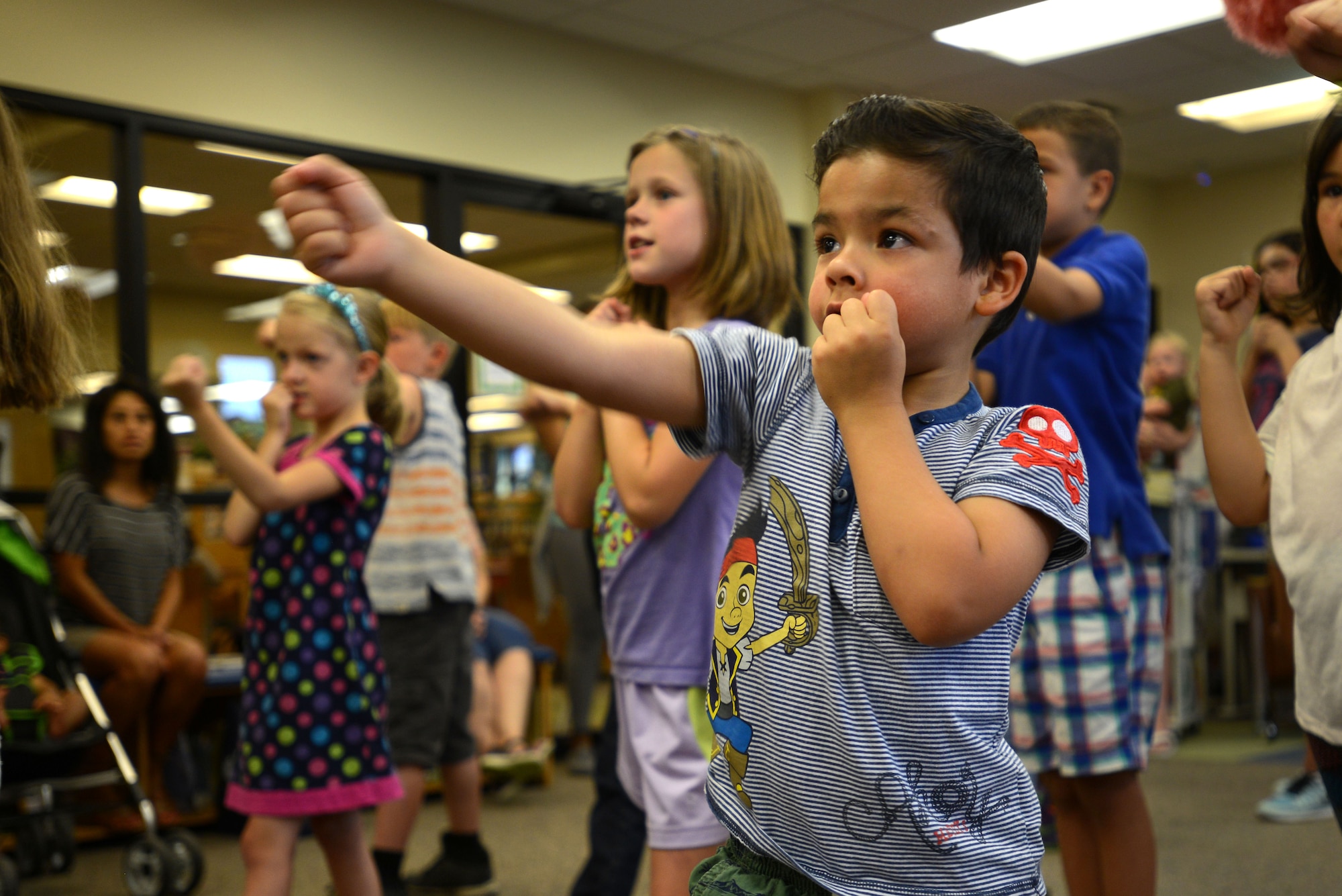 A Team Shaw child throws a punch during a martial arts demonstration at the McElveen Information and Learning Center at Shaw Air Force Base, S.C., June 24, 2016. Members of the Sumter and Shaw communities were invited to give martial arts demonstrations in support of the summer reading program, keeping with the theme ‘Read for the Win’. (U.S. Air Force photo by Airman 1st Class Kelsey Tucker)