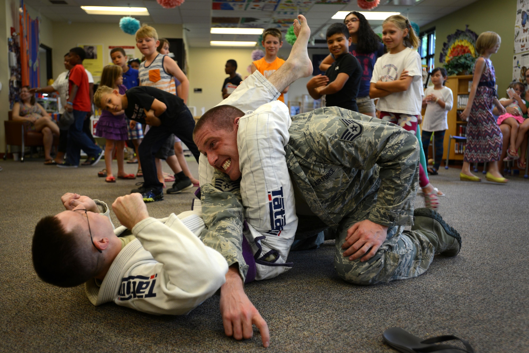 U.S. Air Force Senior Airman Jeffrey Weber, 51st Intelligence Squadron analyst, demonstrates a Brazilian Jiu-Jitsu move on Staff Sgt. Colt Garrett, 51st IS analyst, at the McElveen Information and Learning Center at Shaw Air Force Base, S.C., June 24, 2016. The demonstration, held in support of the library’s summer reading program, focused on defending against bullies, regardless of their size. (U.S. Air Force photo by Airman 1st Class Kelsey Tucker)