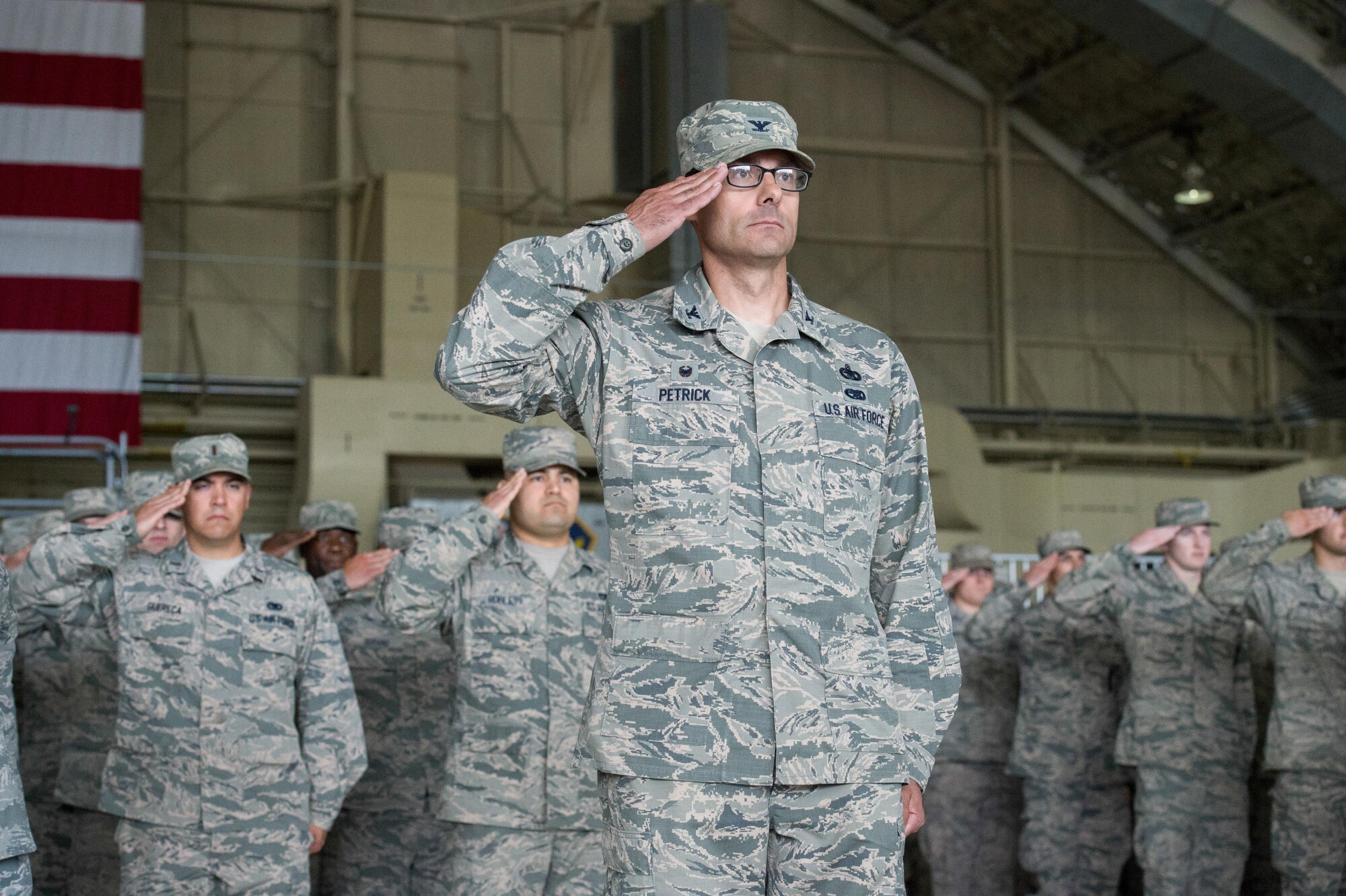 The formation salutes during the 673d Air Base Wing and Joint Base Elmendorf-Richardson, Alaska, change of command ceremony at Hangar 1 on JBER, Monday, July 11, 2016. U.S. Air Force Col. Brian Bruckbauer turned over command to Air Force Col. George Dietrich III as Air Force Lt. Gen. Russell Handy, the appointed commander of Pacific Air Forces, officiated before gathered family members, distinguished guests and military personnel. (U.S. Air Force photo/Justin Connaher)