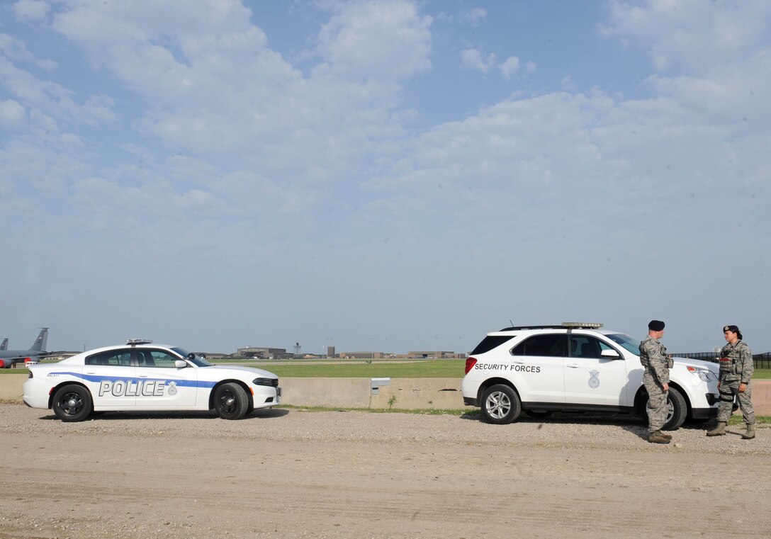 Two 22nd Security Forces Squadron patrolmen talk by the flightline, July 12, 2016, at McConnell Air Force Base, Kan. The new patrol cars have a clearly marked ‘POLICE’ sticker on the side of the car, which is a new Security Forces Center regulation. (U.S. Air Force photo/Senior Airman David Bernal Del Agua)