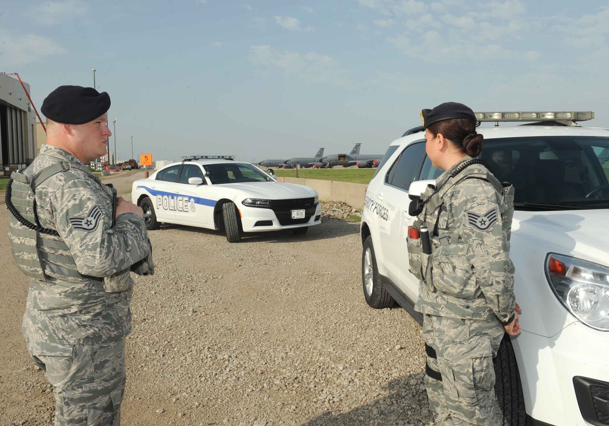 Two security forces Airmen talk on the flightline, July 12, 2016, at McConnell Air Force base, Kan., while inspecting vehicles. The 22nd Security Forces Squadron received a new car to replace a worn down patrol car. The new cars are upgraded and better suited to restrain and carry detainees. (U.S. Air Force photo/Senior Airman David Bernal Del Agua)