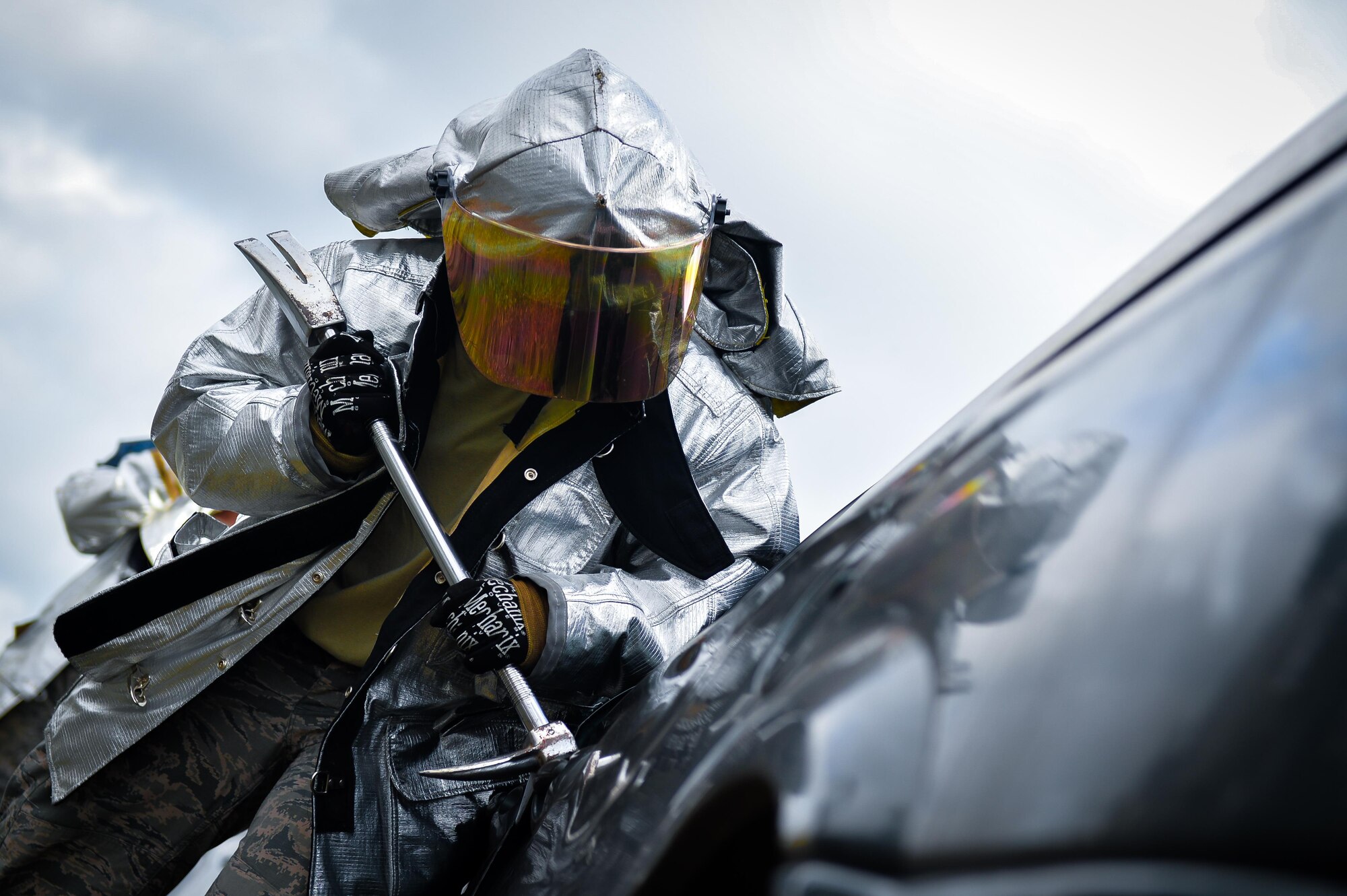 A firefighter from the 2nd Civil Engineer Squadron uses a halligan tool to create a hinge access point during an accident victim extraction exercise at Barksdale Air Force Base, La., July 7, 2016. Access points were created to provide the spreader tool with gaps needed to access hinges as part of the door removal process. (U.S. Air Force photo/Senior Airman Mozer O. Da Cunha)