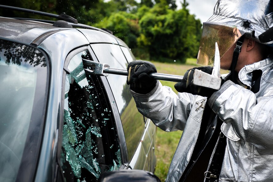 Airman 1st Class Nicolas Rose, 2nd Civil Engineer Squadron firefighter, breaks a car window during an accident victim extraction exercise at Barksdale Air Force Base, La., July 7, 2016. Rose performed a controlled break prior to removing the vehicle door. (U.S. Air Force photo/Senior Airman Mozer O. Da Cunha)