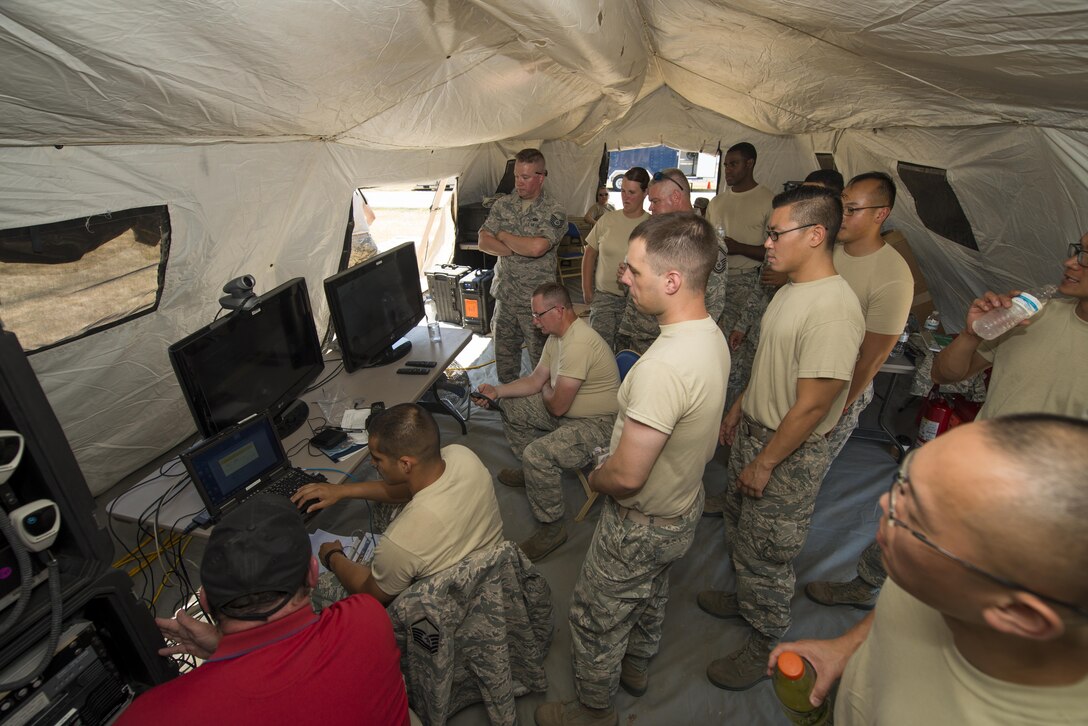 Members of Air Force Reserve squadrons gather as video teleconference equipment is set up during the Air Force Reserve Command Joint Incident Site Communications Capability (JISCC) exercise, July 12, 2016, Niagara Falls Air Reserve Station, N.Y. The exercise is meant to simulate how units would deploy anywhere in the U.S. to enable inter-agency communication during a man-made or natural disaster. (U.S. Air Force photo by Tech. Sgt. Stephanie Sawyer) 

