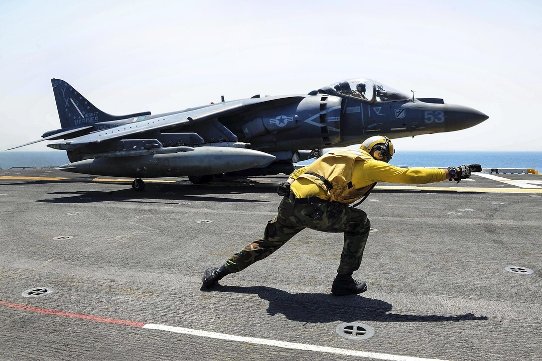 Navy Petty Officer 3rd Class Chase Coker launches an AV-8B Harrier II off the flight deck of amphibious assault ship USS Boxer in the Arabian Gulf, July 11, 2106. The Boxer is supporting Operation Inherent Resolve in the 5th Fleet area of operations. Coker is an aviation boatswain's mate handling. Navy photo by Petty Officer 2nd Class Jose Jaen