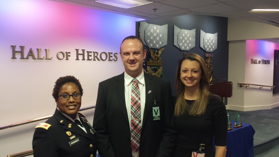 Army Col. Delisa Hernandez, director of Defense Contract Management Agency Raytheon Tewksbury in Massachusetts, and Jennifer Connell, wife of DCMA employee Ryan Connell, congratulate him on receiving a 2015 Defense Acquisition Workforce Individual Achievement and Development Award Dec. 10.