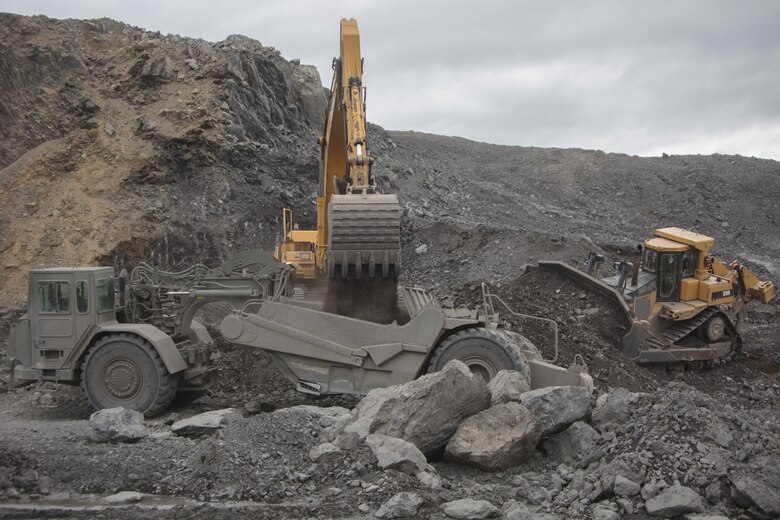 Heavy equipment operators from across Marine Forces Reserve move material to complete a runway extension project at Innovative Readiness Training Old Harbor, Alaska, July 9, 2016. The project would extend the existing Old Harbor runway by 2,000 feet, which would allow larger aircraft to land in Old Harbor. IRT Old Harbor is part of a civil and joint military program to improve military readiness while simultaneously providing quality services to underserved communities throughout the United States. (U.S. Marine Corps photo by Sgt. Ian Leones/released)