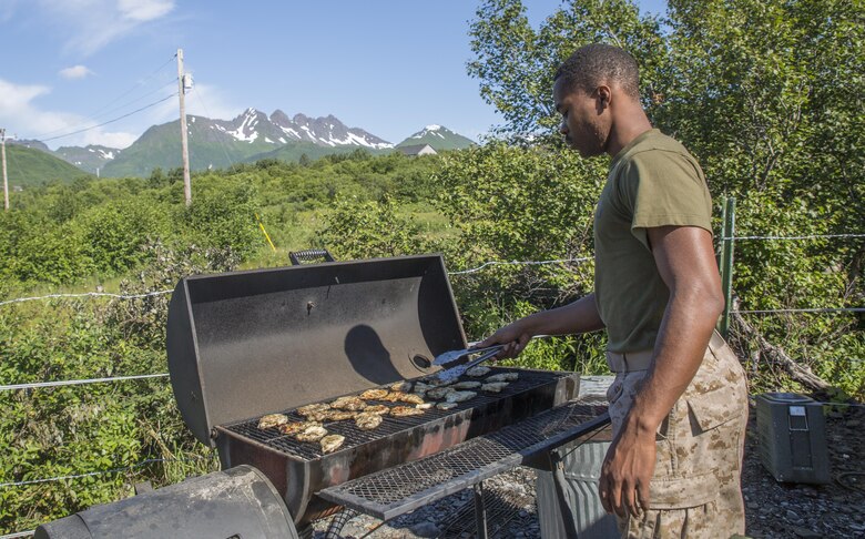 Lance Cpl. Dexter Gray-Harriday, a food service specialist with Detachment A, Marine Wing Support Squadron-472, Marine Aircraft Group 49, 4th Marine Aircraft Wing, Marine Forces Reserve, prepares chicken at Innovative Readiness Training Old Harbor, Alaska, July 11, 2016. The training brought the Marines back to their expeditionary roots and required them to setup electricity, water and other resources to survive in the remote Alaskan environment.  IRT Old Harbor is part of a civil and joint military program to improve military readiness while simultaneously providing quality services to underserved communities throughout the United States. (U.S. Marine Corps photo by Sgt. Ian Leones/released)