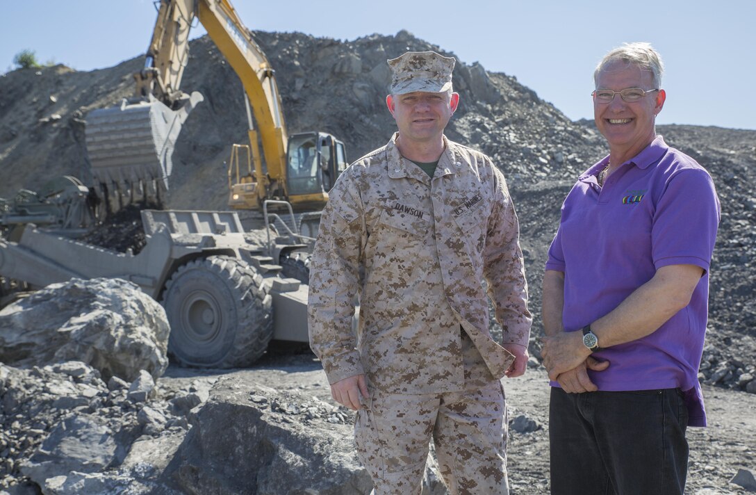 Lt. Col. Vincent C. Dawson, commanding officer of Marine Wing Support Squadron-473, Marine Aircraft Group 41, 4th Marine Aircraft Wing, Marine Forces Reserve, and Rick Berns, mayor of Old Harbor, Alaska, stand in front of the Old Harbor airport runway extension project at Innovative Readiness Training Old Harbor, July 11, 2016. IRT Old Harbor is part of a civil and joint military program to improve military readiness while simultaneously providing quality services to underserved communities throughout the United States. (U.S. Marine Corps photo by Sgt. Ian Leones/released)