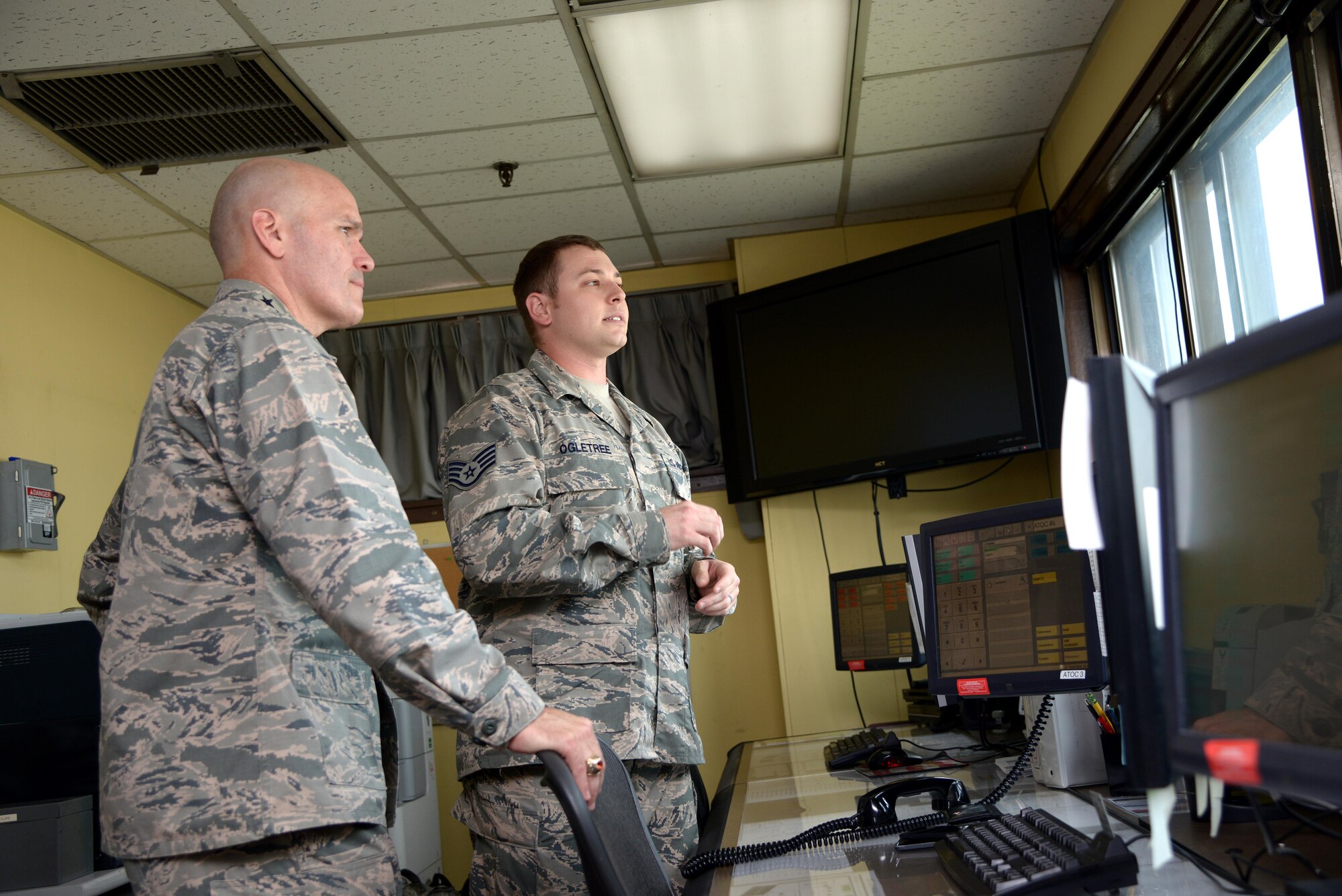 Gen. Carlton D. Everhart II, Air Mobility Command commander, gets briefed by Staff Sgt. Cody Ogletree, 731st Air Mobility Squadron cape forecaster, about his role providing aerial port command and control at the 731st AMS Air Terminal Operations Center at Osan Air Base, Republic
of Korea, July 11, 2016. While visiting Osan AB, the general had lunch with the Airmen from the 731st AMS and toured their  facilities to interact with the Airmen and civilians who work to provide precise, reliable airlift worldwide every day. (U.S. Air Force photo by Tech.Sgt. Rasheen Douglas/Released)
