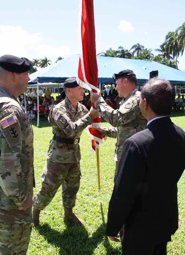 Lt. Col. James D. Hoyman (back right) receives the unit colors from former Pacific Ocean Division Commander Brig. Gen. Jeffrey L. Milhorn, becoming the 70th Commander of the U.S. Army Corps of Engineers Honolulu District. Looking on are outgoing District Commander Lt. Col. Christopher W. Crary (front left) and Acting Honolulu District Deputy District Engineer for Programs and Project Management Stephen Cayetano. Milhorn presided over the ceremony on the Palm Circle Parade Field at Fort Shafter. 