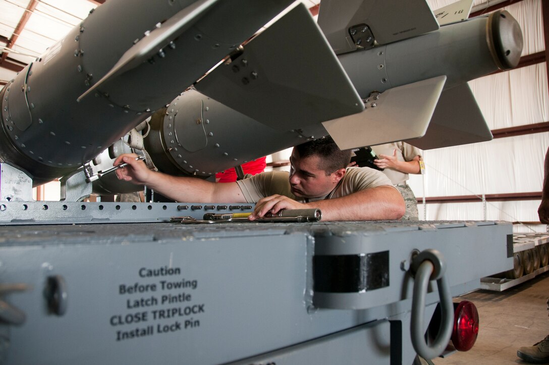 U.S. Air Force Airman 1st Class Randal Trosky, 1st Maintenance Squadron, and Tech. Sgt. Kenneth Stanley, 192nd MXS, ordnance maintenance mechanics, train together while building eight Mark 83 inert bombs for an exercise commemorating Maj. Gen. Billy Mitchell’s bombing of the German battleship Ostfriesland, at Langley Air Force Base, Va., July 10, 2016. Mitchell, often referred to as the ‘Father of the Air Force’, sunk the ship to prove a case for the power of an independent air service.  (U.S. Air National Guard photo by Master Sgt. Carlos J. Claudio)