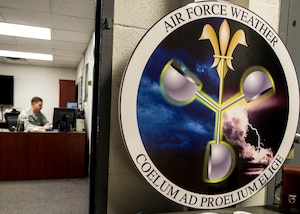 The U.S. Army Air Force Air Weather Service badge is displayed in front of the 1st Operations Support Squadron weather shop at Fort Eustis, Va., June 22, 2016. The badge has a gold fleur-de-lois with the unit's motto ‘COELUM AD PROELIUM ELIGE’ which means,I select the weather for battle. (U.S. Air Force photo by Airman 1st Class Derek Seifert)