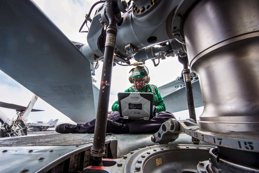 Navy Seaman Janeih Bain performs maintenance on the rotor hub of an MH-60R Seahawk helicopter on the flight deck of the USS Carl Vinson in the Pacific Ocean, July 11, 2016. The Vinson is conducting  Tailored Ship's Training Availability and Final Evaluation Problem to prepare for deployment. Bain is an aviation machinist’s mate assigned to Helicopter Maritime Strike Squadron 78. Navy photo by Seaman Daniel P. Jackson Norgart