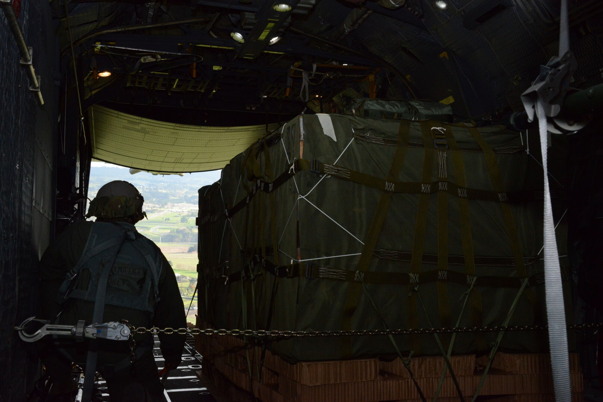 A 1st Special Operations Squadron loadmaster prepares to drop a container delivery system bundle over a drop zone in New Zealand June 20, 2016. Members from the 353rd Special Operations Group participated in Exercise Teak Net June 12 through 30 in Whenuapai, New Zealand. During the exercise, members from both the New Zealand Defense Force and U.S. Air Forces worked together to conduct personnel and equipment air drops while exchanging new techniques. (U.S. Air Force photo by Master Sgt. Kristine Dreyer)