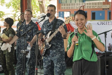 160621-N-OU129-270 PATTAYA, Thailand (June 21, 2016) The U.S. Navy 7th Fleet Rock Band "Orient Express" invites a student from the Potisampan School to sing a local song during a joint rock concert with the Royal Thai Marine Corps Band in support of Cooperation Afloat Readiness and Training (CARAT) Thailand 2016 in Pattaya Thailand, June 21, 2016. CARAT is a series of annual maritime exercises between the U.S. Navy, U.S. Marine Corps and the armed forces of nine partner nations to include Bangladesh, Brunei, Cambodia, Indonesia, Malaysia, the Philippines, Singapore, Thailand, and Timor-Leste. (U.S. Navy photo by Mass Communication Specialist 2nd Class Joshua Fulton)