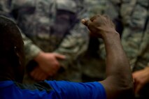 Retired U.S. Air Force Chief Master Sgt. Juan Lewis, known as the Fired Up Chief, raises his hand while speaking to NCOs during a Tier II private organization meeting at the Brick House on Spangdahlem Air Base, Germany, July 12, 2016. Lewis spoke about passion, enthusiasm and pride and how the three elements intersect for effective NCO leadership. (U.S. Air Force Photo by Staff Sgt. Joe W. McFadden/Released)
