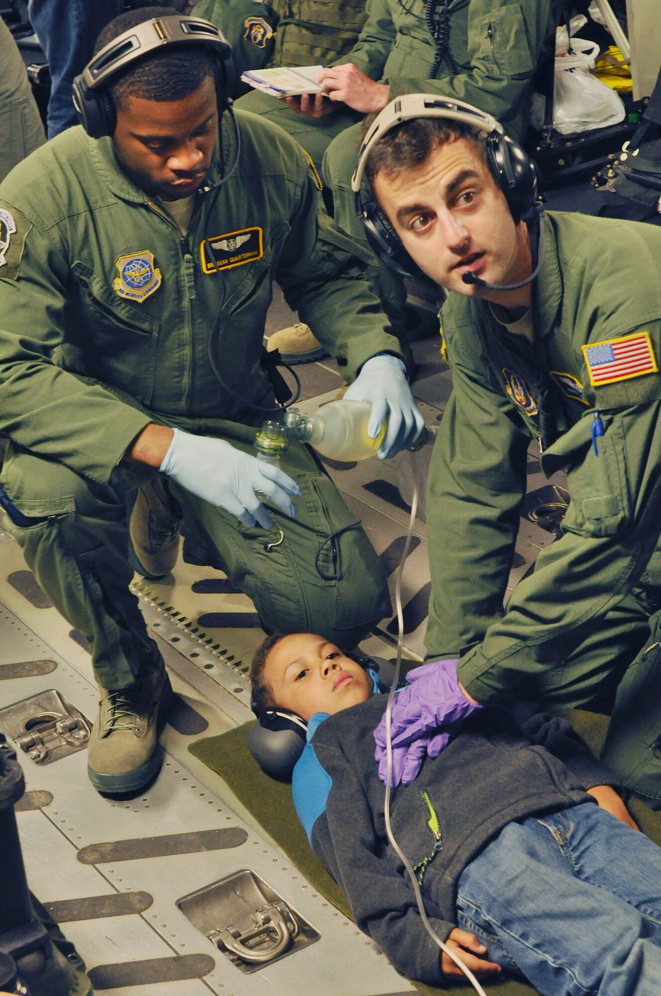 U.S. Air Force Senior Airman Sean Quarterman, 43rd Aeromedical Evacuation Squadron, left,  and Staff Sgt. Rocco L. Morello, right,  practice chest compressions on a child, July 7, 2016, on a flight to Naval Station Rota, Spain. The crew accomplished more than 400 medical training events on the training mission aboard a C17 Globemaster III. (U.S. Air Force photo/Senior Airman Jasmine Zielomski)