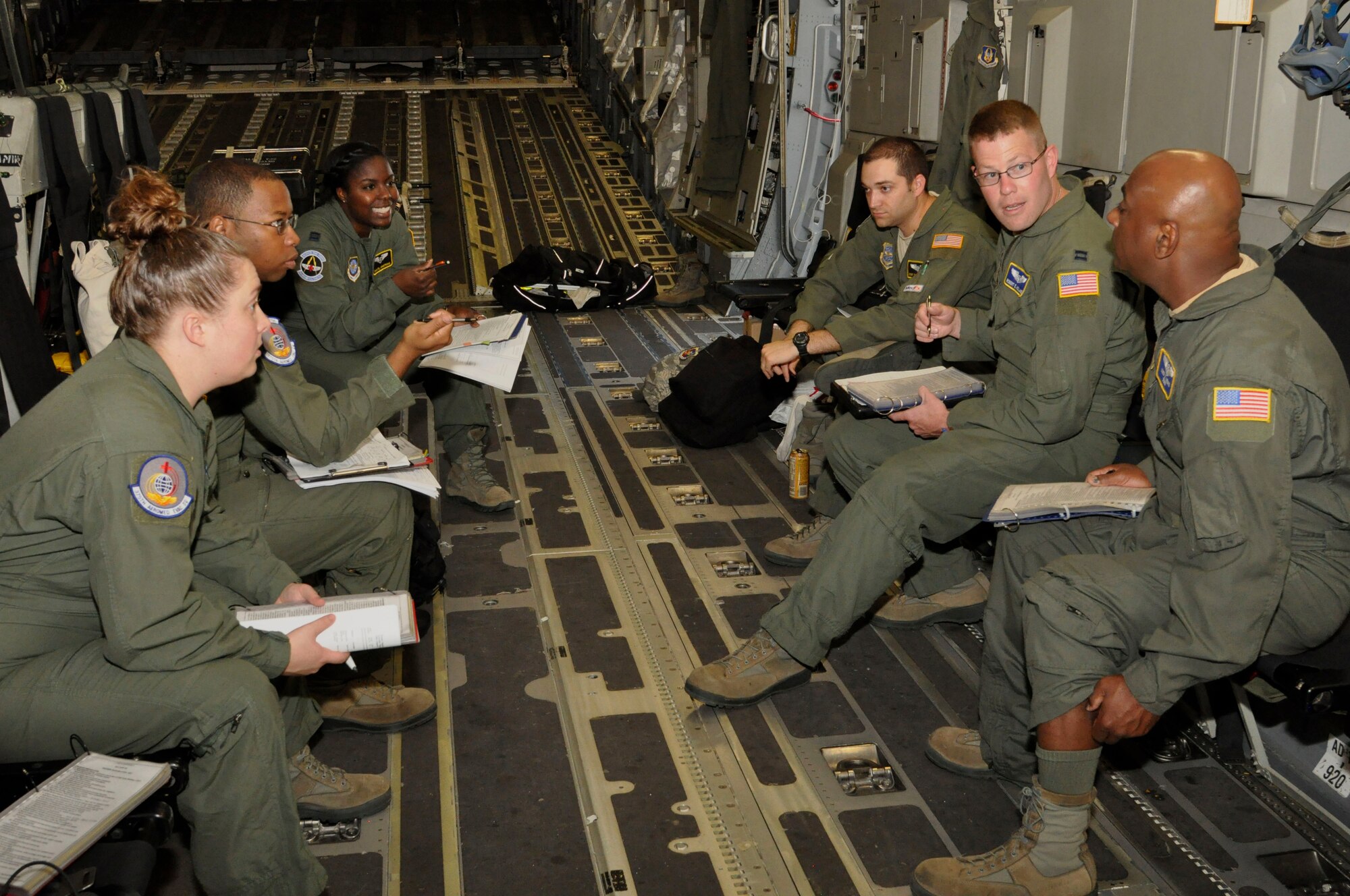 Several U.S. Air Force Airmen assigned to the 514th AES, 375th AES and 43rd AES, conduct a pre-flight brief and review checklists, July 8, 2016 on a flight to RAF Mildenhall, England. The crew accomplished more than 400 medical training events on the training mission aboard a C17 Globemaster III. (U.S. Air Force photo/Senior Airman Jasmine Zielomski)