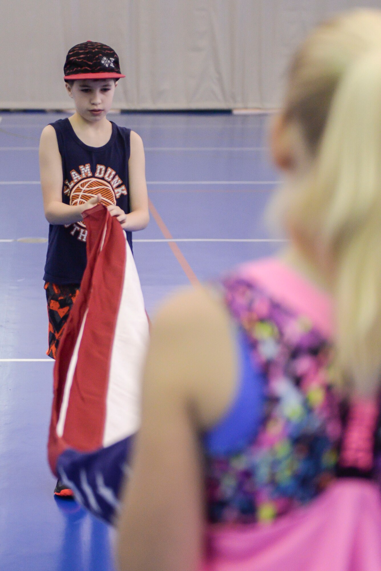 Andrew Seibel folds a flag during the Honor Guard flag-folding demonstration during the Youth Boot Camp at Minot Air Force Base, N.D., July 7, 2016. The Honor Guard came to the Youth Center to teach the proper customs and courtesies when folding the American flag during a ceremony. (U.S. Air Force photo/Airman 1st Class Jessica Weissman)