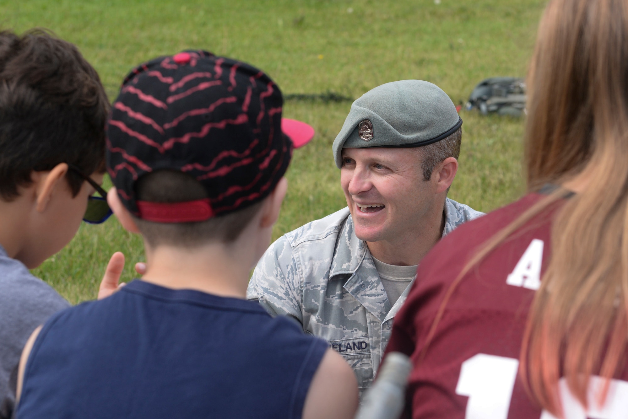 Tech. Sgt. Clifton Cleveland, a Survival, Evasion, Resistance and Escape specialist assigned to the 5th Operations Support Squadron, answers questions before beginning the first activity of survival training during the Youth Center Boot Camp at Minot Air Force Base, N.D., July 7, 2016. Children learned how to quickly build shelter during a survival situation. (U.S. Air Force photo/Airman 1st Class Jessica Weissman)