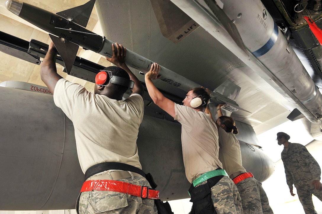 Airmen work together to lift an AIM-9L/M Sidewinder missile onto an Air Force F-15C Eagle during a weapons load competition at Kadena Air Base, Japan, July 11, 2016. Air Force photo by Naoto Anazawa