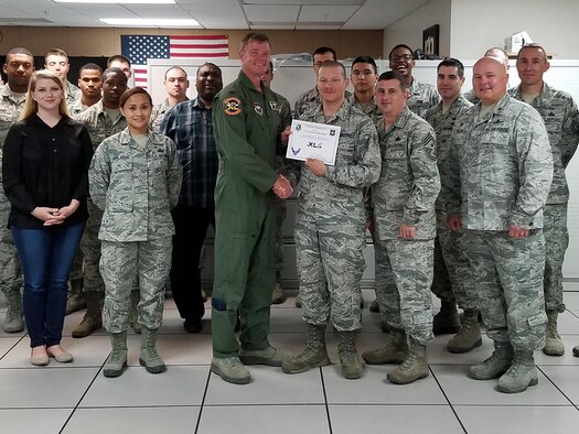 Airman 1st Class Patrick Bova-Ruiz, 47th Communications Squadron fiber transport technician, accepts the “XLer of the Week” award from Col. Thomas Shank, left, 47th Flying Training Wing commander, and Chief Master Sgt. George Richey, 47th FTW command chief, here, July 6, 2016. The XLer is a weekly award chosen by wing leadership and is presented to those who consistently make outstanding contributions to their unit and Laughlin. (Courtesy photo)