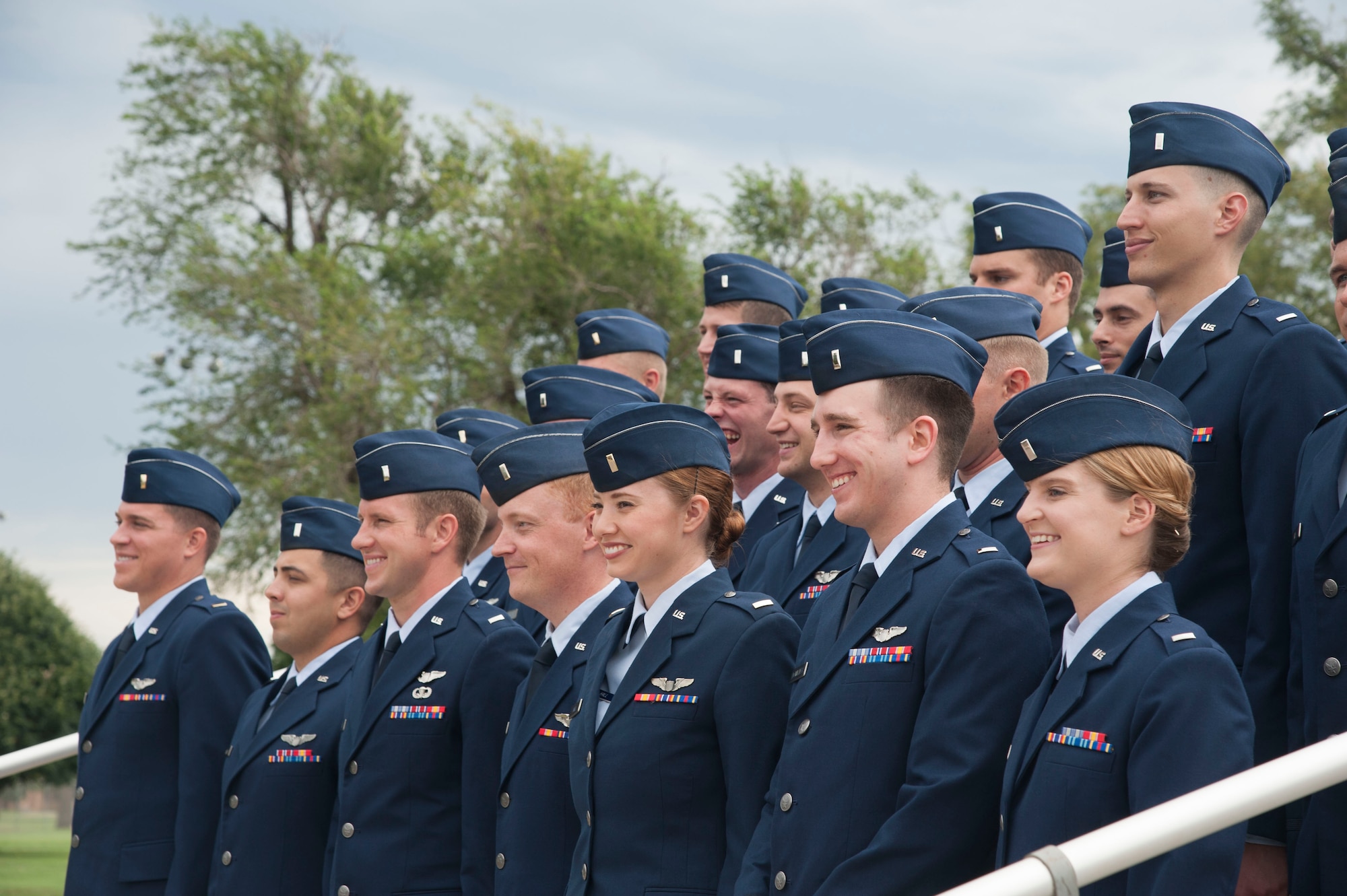 New pilots stage a photo op for family and friends while awaiting a graduation fly-over at Vance Air Force Base, Oklahoma. Twenty-two junior officers received their pilot wings during Class 16-11’s graduation ceremony July 8. (U.S. Air Force photo by Staff Sgt. Nancy Falcon)