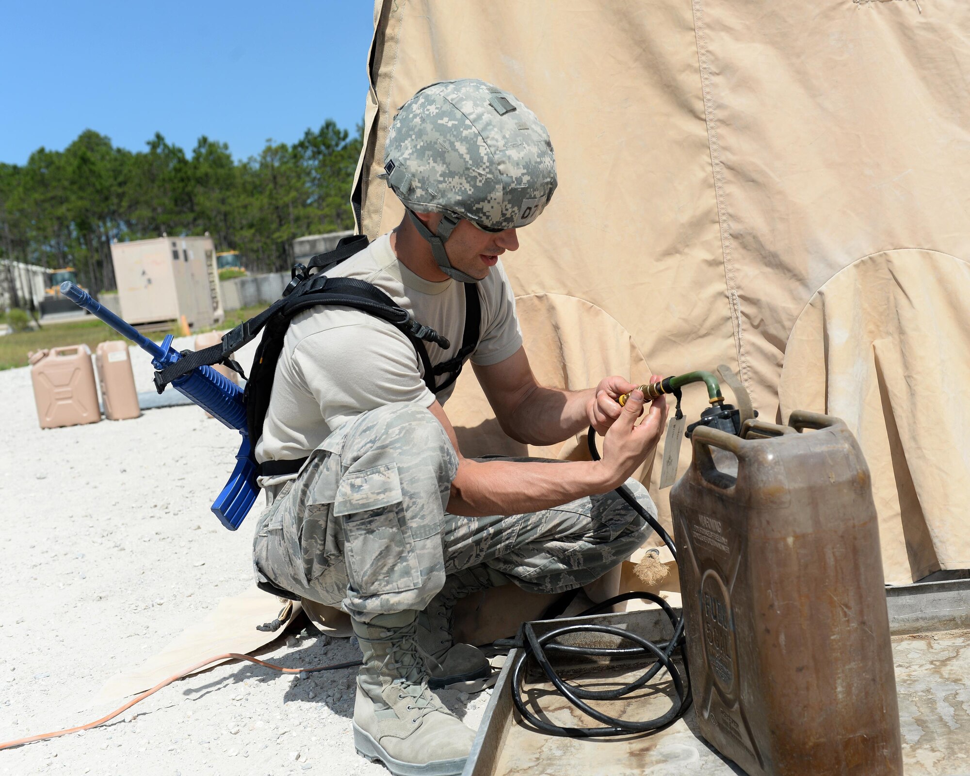 U.S. Air Force Senior Airman Casey Belieu, 104th Fighter Wing services specialist, Barnes Air National Guard Base, Westfield, Mass., connects a fuel tank to a tent-covered kitchen at the Silver Flag exercise site at Tyndall Air Force Base, Fla., June 23, 2016. Services specialists from the 104th came to the Silver Flag site to learn how to conduct their duties in a deployed environment. (U.S. Air Force photo by Airman 1st Class Cody R. Miller/Released)