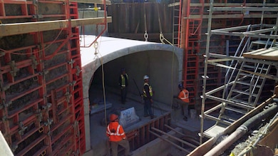 Installation of a precast concrete culvert section. Note the attached granite veneer on the culvert face and the formwork and rebar for the wingwalls on either side of the precast culvert – mid October 2015.