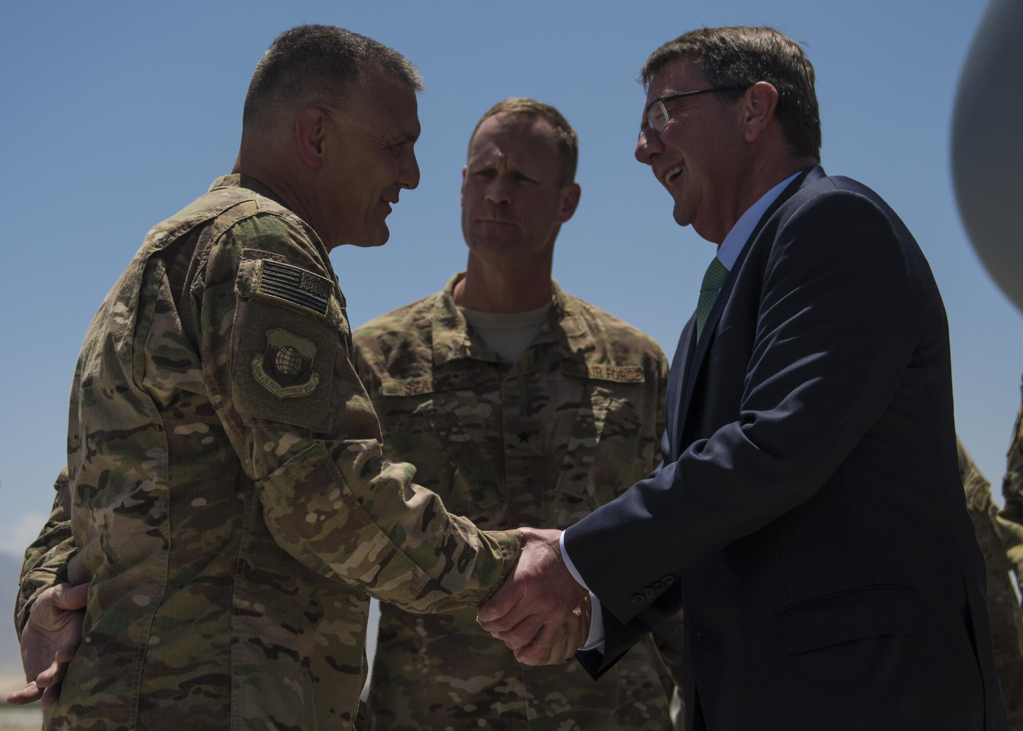 Command Chief Master Sergeant Peter Speen (left), 455th Air Expeditionary Wing command chief, shakes hands with Secretary of Defense Ashton Carter, and talks with Brig. Gen. James Sears (middle), 455th Air Expeditionary Wing commander, July 12, 2016, Bagram Airfield, Afghanistan. Carter visited Afghanistan to meet with Afghan President Ghani, Resolute Support leadership and service members to discuss the U.S. mission in Afghanistan. (U.S. Air Force photo by Senior Airman Justyn M. Freeman)