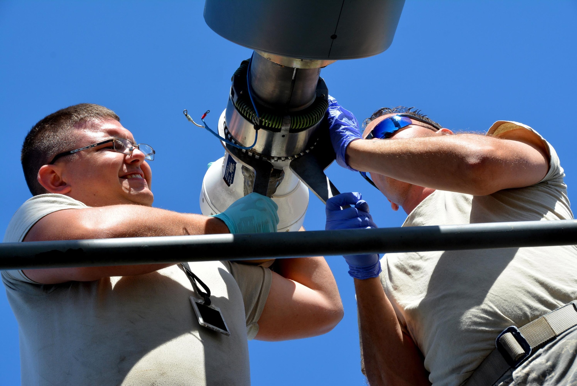 JOINT BASE PEARL HARBOR-HICKAM (July 10, 2016) (from left to right) Staff Sgt. James Andrus  and Senior Airman Travis Krause, U.S. Air Force crew chiefs with the 507th Aircraft Maintenance Squadron at Tinker Air Force Base, Okla., use expander wrenches to remove the boom nozzle from a KC-135R Stratotanker in order to connect a drogue adapter and drogue. The probe and drogue method of refueling uses a trailing hose with a basket on the end. Pilots guide a probe on their aircraft into the basket to connect with the hose. Air Force helicopters and all Navy and Marine Corps aircraft refuel using the hose-and-drogue for air-to-air refueling. Andrus, Krause and other Citizen Airmen are participating in the 25th Rim of the Pacific Exercise, which began in 1971 Twenty-six nations, more than 40 ships and submarines, more than 200 aircraft, and 25,000 personnel are participating in RIMPAC from June 30 to Aug. 4, in and around the Hawaiian Islands and Southern California. RIMPAC is the world's largest international maritime exercise, which provides a unique training opportunity that helps participants foster and sustain cooperative relationships that are critical to ensuring the safety of sea lanes and security on the world's oceans. (U.S. Air Force photo/Master Sgt. Grady Epperly/Released)