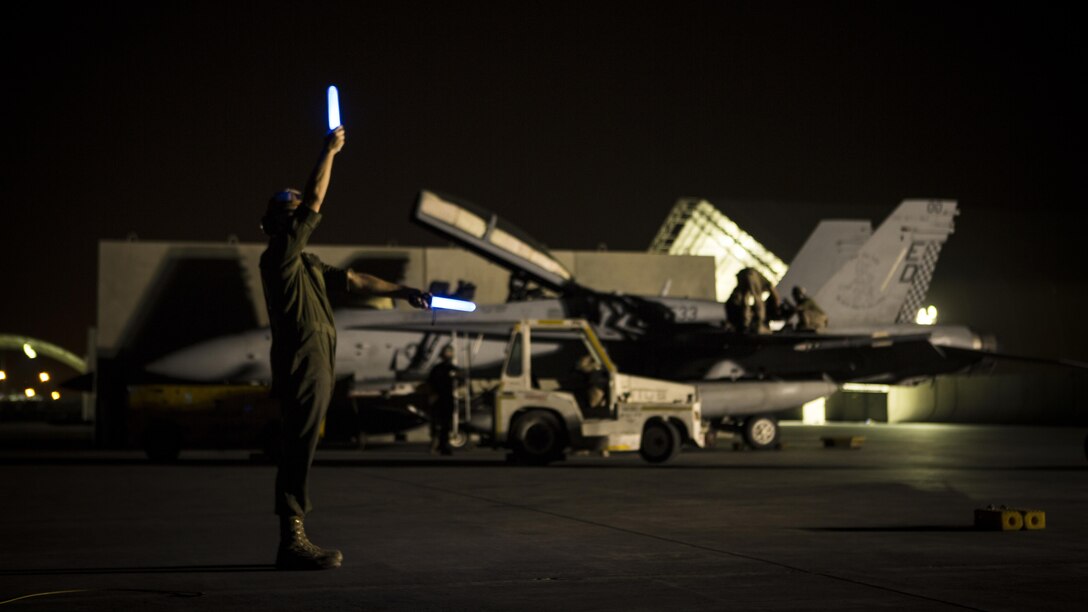 A U.S. Marine with Marine All-Weather Fighter Attack Squadron 533, Special Purpose Marine Air Ground Task Force - Crisis Response - Central Command 16.2, directs flight line traffic at an undisclosed location in Southwest Asia, June 8, 2016. VMFA(AW)-533 operates and conducts strikes as part of the Aviation Combat Element of SPMAGTF-CR-CC in support of Operation Inherent Resolve, the operation to eliminate the ISIL terrorist group and the threat they pose to Iraq, Syria, and the wider international community. (U.S. Marine Corps photo by Sgt. Donald Holbert/ Released)