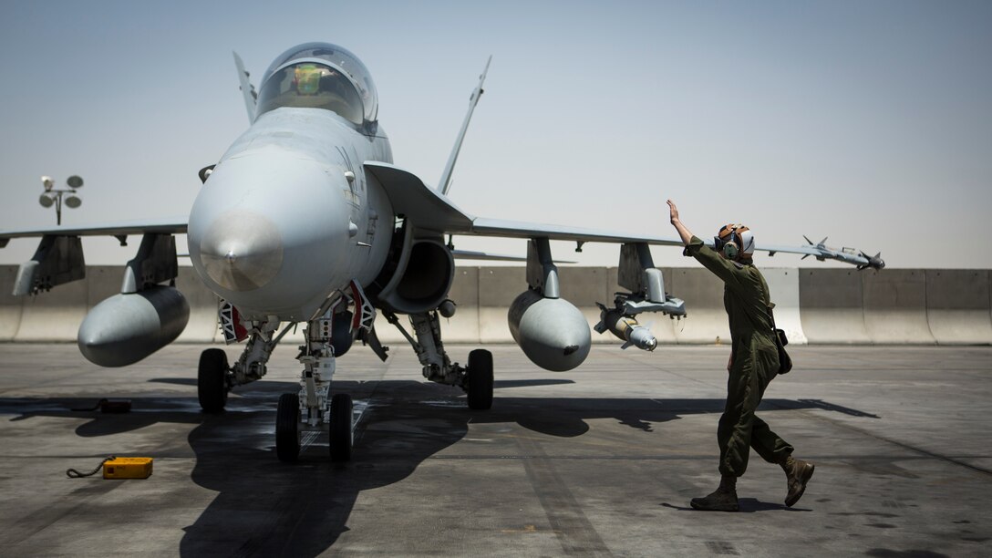 A U.S. Marine with Marine All-Weather Fighter Attack Squadron 533, Special Purpose Marine Air Ground Task Force - Crisis Response - Central Command 16.2, directs an F/A-18D Hornet returning to an undisclosed location in Southwest Asia, June 9, 2016. VMFA(AW)-533 operates and conducts strikes as part of the Aviation Combat Element of SPMAGTF-CR-CC in support of Operation Inherent Resolve, the operation to eliminate the ISIL terrorist group and the threat they pose to Iraq, Syria, and the wider international community. (U.S. Marine Corps photo by Sgt. Donald Holbert/ Released)