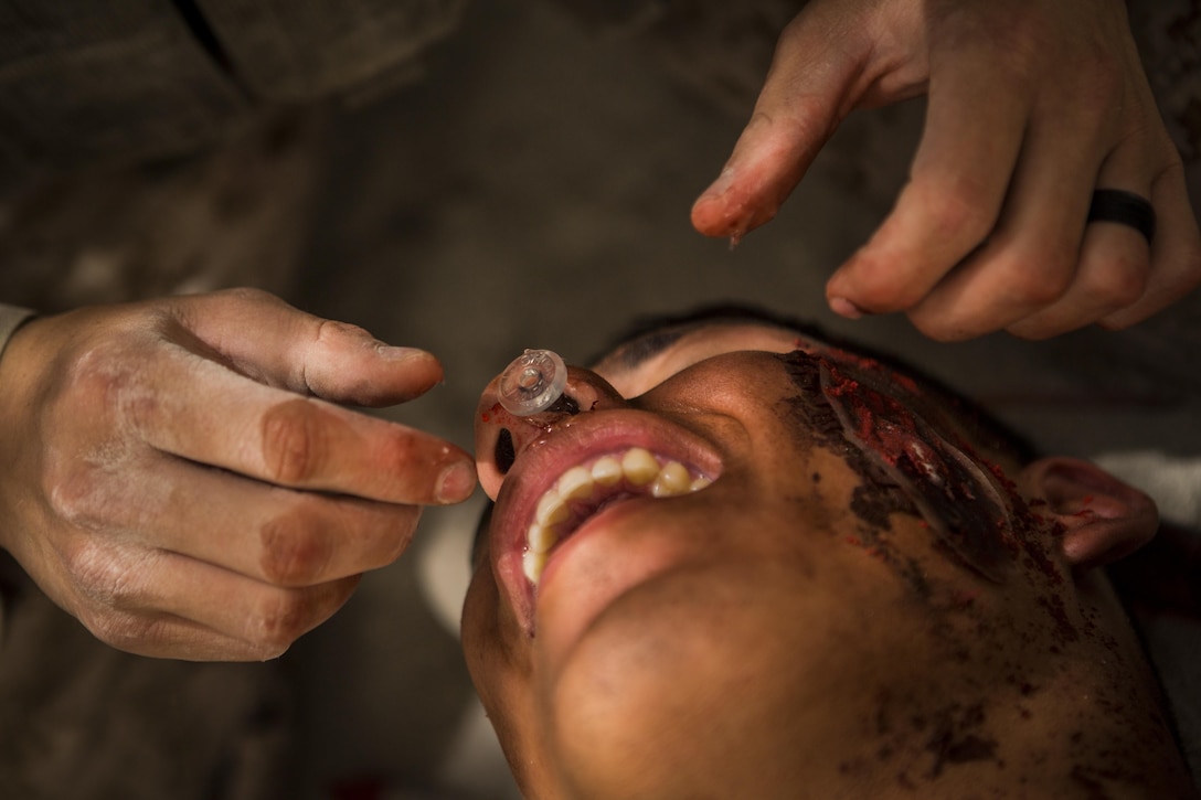 A U.S. Marine administers a nasopharyngeal airway to Cpl. Joe Tamayo, a heavy equipment operator,  with Company C, Marine Wing Support Squadron 373, Special Purpose Marine Air Ground Task  Force – Crisis Response - Central Command, during the final exam of a combat lifesaver course, June 17, 2016. SPMAGTF-CR-CC is currently forward deployed in several host nations, with the ability to respond, rapidly, to a variety of contingencies. (U.S. Marine Corps photo by Sgt. Donald Holbert/ Released)