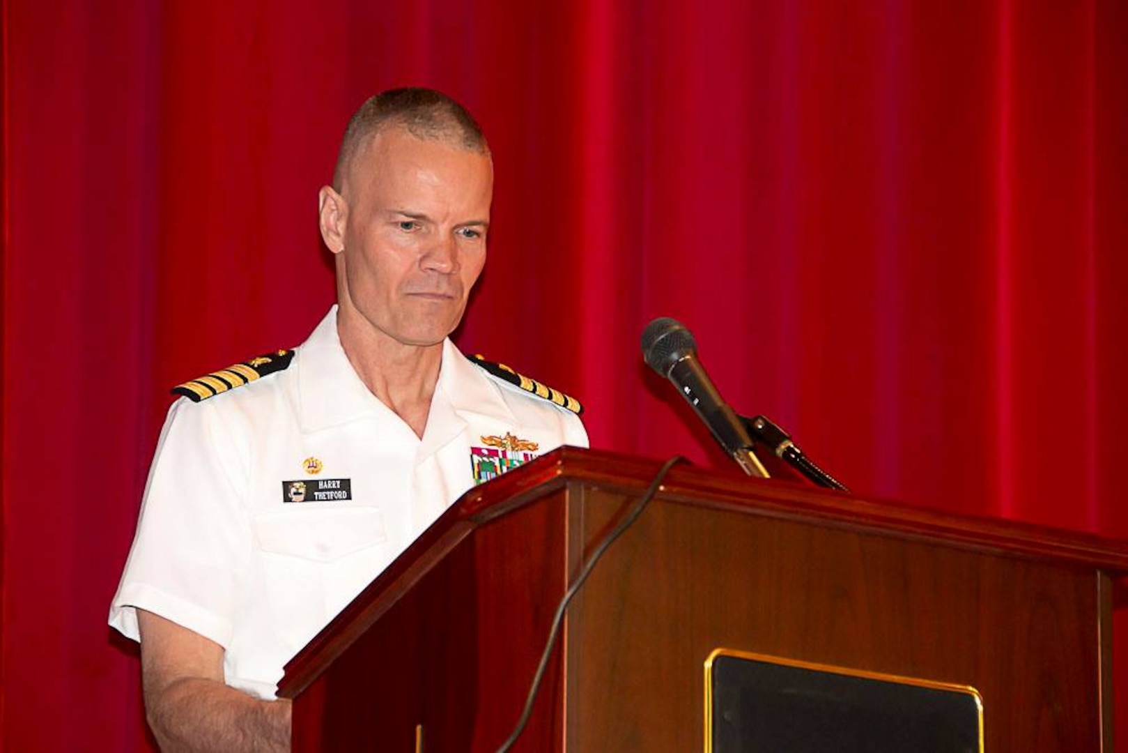 Navy Capt. Harry Thetford, commander of Defense Logistics Agency Distribution Norfolk, Va., speaks to newly-graduated Navy Junior Reserve Officer Training Corps students in the Norfolk area.