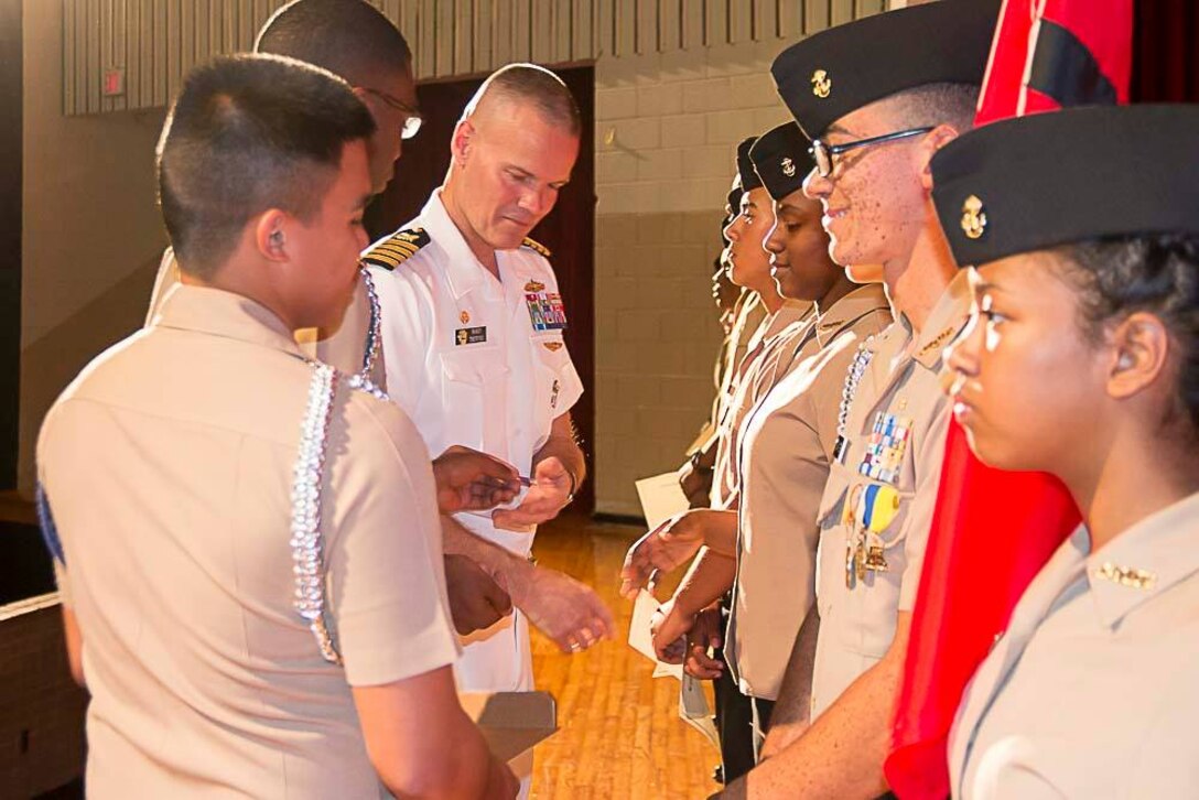 Navy Capt. Harry Thetford, commander of Defense Logistics Agency Distribution Norfolk, Va., speaks to some of the Navy Junior Reserve Officer Training Corps after their graduation ceremony.