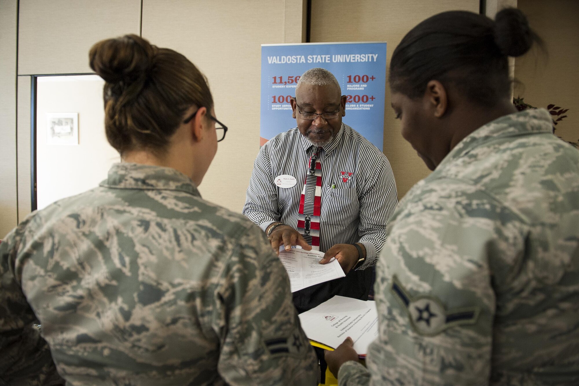 Mark Smith, a representative from Valdosta State University, briefs Airmen about education opportunities during the National Education Fair, July, 13, 2016, at Moody Air Force Base, Ga. More than 25 agencies and institutions were represented at the event to assist Airmen and families with their educational inquiries. (U.S. Air Force photo by Airman 1st Class Lauren M. Hunter)