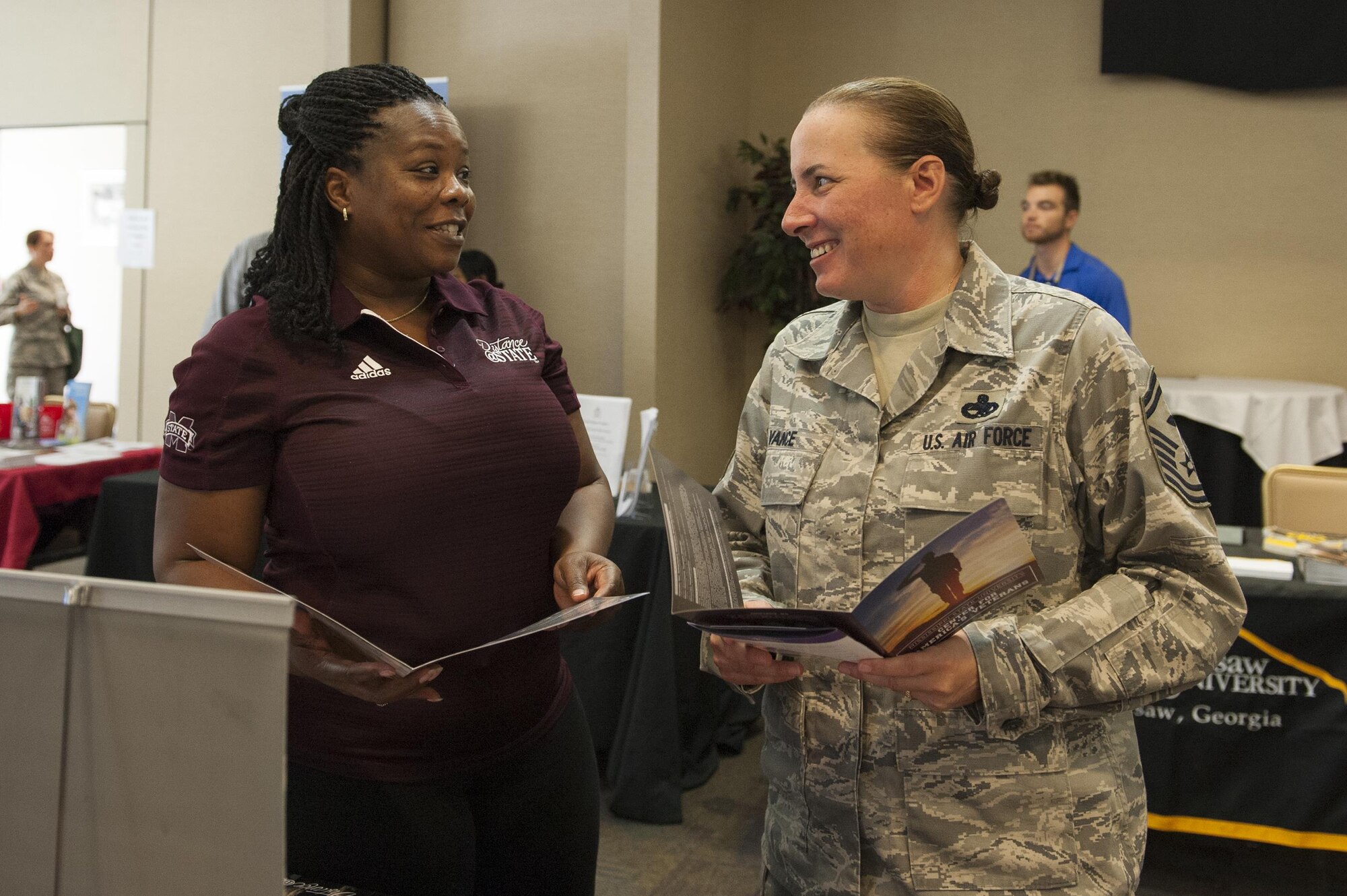 Valerie Tate, Mississippi State University coordinator, explains education opportunities to U.S. Air Force Senior Master Sgt. Charlene Vance, 723d Aircraft Maintenance Squadron first sergeant, during the National Education Fair, July 13, 2016, at Moody Air Force Base, Ga. Education representatives offered attendees a variety of options to pursue their education, as well as information about general courses, electives and semester hours required to complete their programs. (U.S. Air Force photo by Airman 1st Class Lauren M. Hunter)