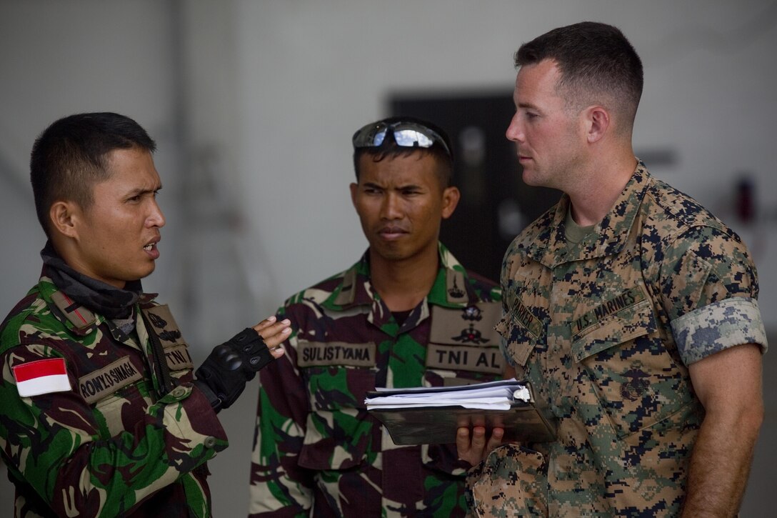 A U.S. Marine and two Indonesian Soldiers discuss the manifest roster as part of Ground Air Integration Training on July 6, 2016 on Marine Corps Base Hawaii. This training is designed to enhance the interoperability of the combined RIMPAC forces during military operations in the maritime environment. Exercise Rim of the Pacific 16 is the world's largest international maritime exercise, and provides a unique training opportunity that helps participants foster and sustain cooperative relationships that are critical to ensuring the safety of sea lanes and on the world's oceans. RIMPAC 2016 is the 25th exercise in the series that began in 1971.