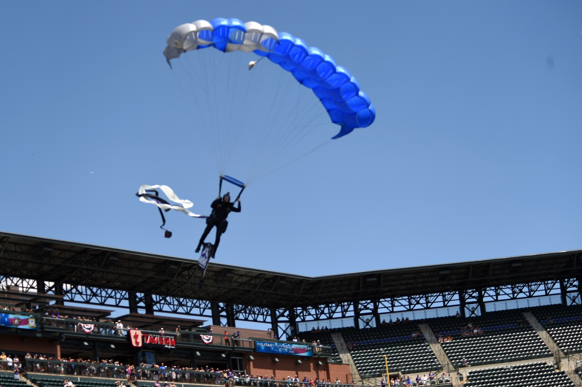 U.S. Air Force skydiving team member with the Wings of Blue parachutes into Coors Field July 10, 2016, in Denver. during a military appreciation ceremony. The Wings of Blue demonstration team takes part in events across the country, such as airshows, sporting events and other events to represent the Air Force. (U.S. Air Force photo by Airman 1st Class Gabrielle Spradling/Released)