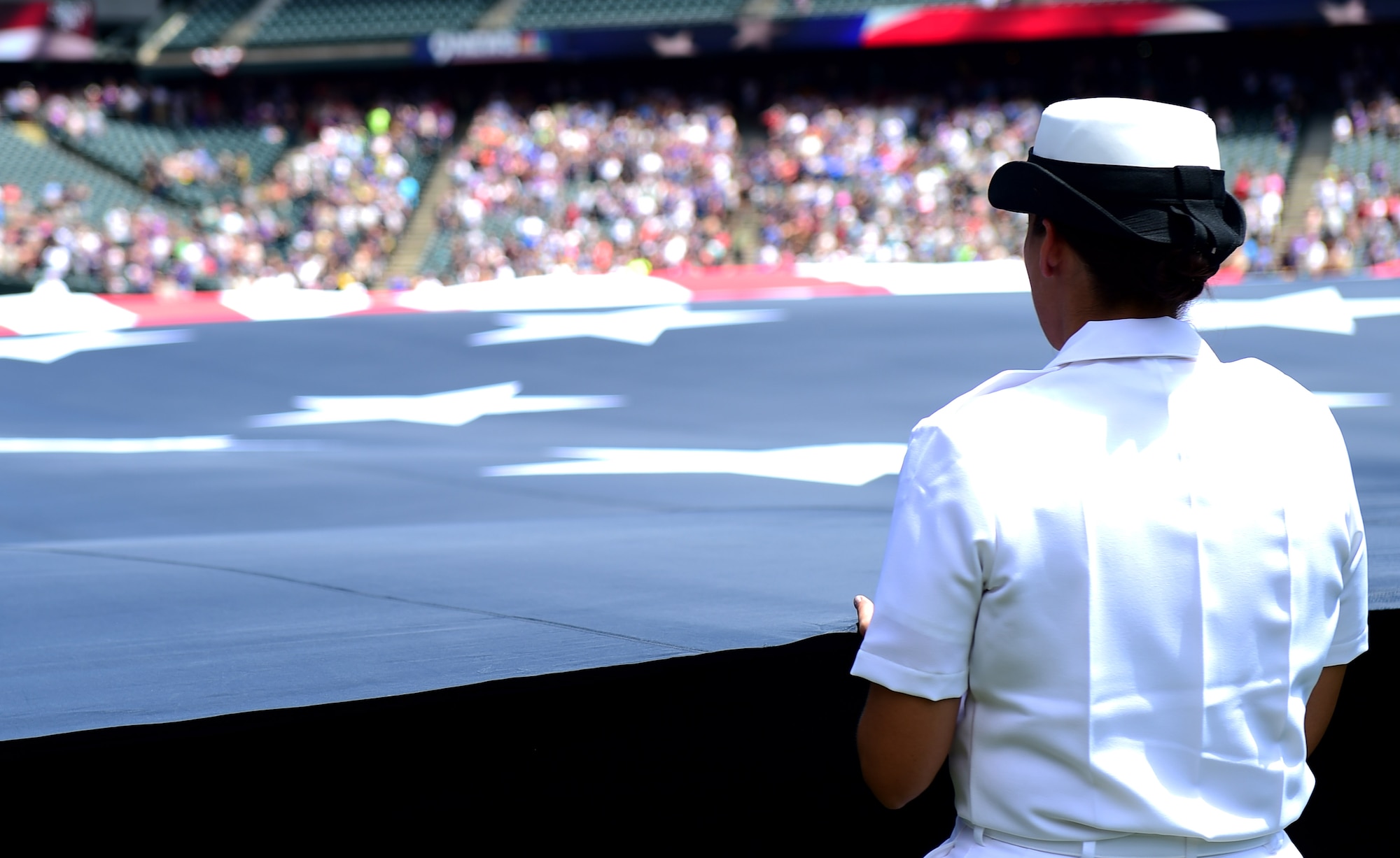 A Service member holds an American flag July 10, 2016, during a military appreciation ceremony at a Colorado Rockies game at Coors Field in Denver. The ceremony included the flag stretched out in the outfield, the singing of the National Anthem and the ringing of the Honor Bell. (U.S. Air Force photo by Airman 1st Class Gabrielle Spradling/Released)