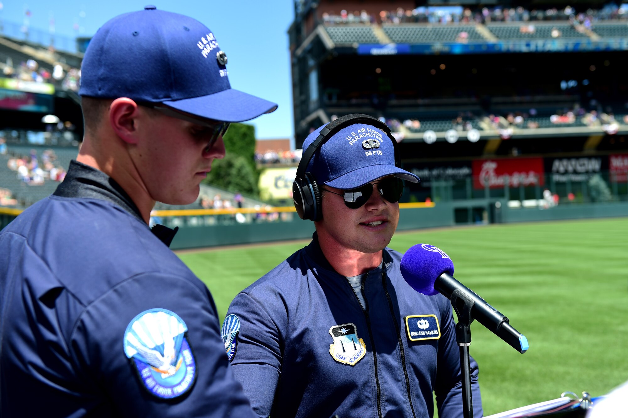 U.S. Air Force skydiving team members with the Wings of Blue announce parachuting Airmen July 10, 2016, during a military appreciation ceremony at a Colorado Rockies game at Coors Field in Denver. The Wings of Blue started when a band of bootleg jumpers made their first parachute jumps as cadets in the spring of 1962. (U.S. Air Force photo by Airman 1st Class Gabrielle Spradling/Released)