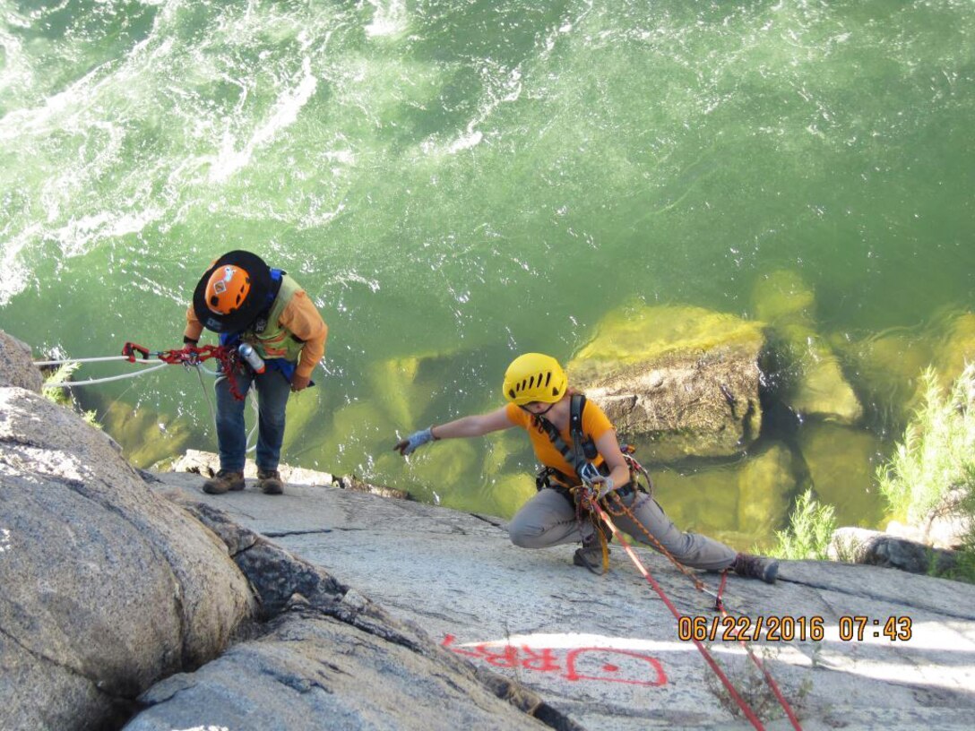 Coralie Wilhite, a geological engineer for the U.S. Army Corps of Engineers Sacramento District, marks rock bolt anchor locations on the bank of the American River near Folsom Dam as part of the Joint Federal Project.