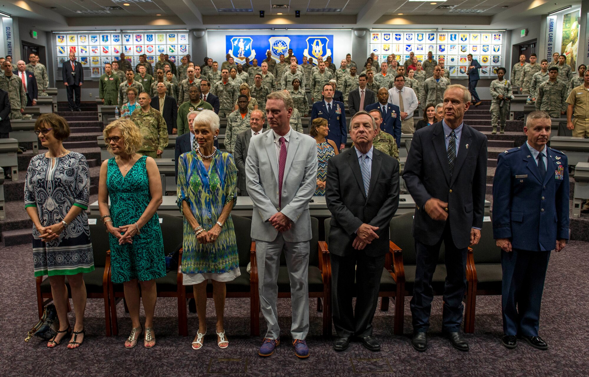 Former Ill. Sen. Alan J. Dixon's family, Ill. Sen. Dick Durbin, Ill. Gov. Bruce Rauner, and Col. Chris Buscher, 37th Air Mobility Wing vice commander, stand as the Scott Air Force Base honor guard enters the room for the Dixon dedication at Scott Air Force Base, Ill., July 8, 2016. The visitor center was dedicated to Dixon, who gave 43 years of public service to Scott AFB and the state of Ill. (U.S. Air Force photo by Jodi Martinez/Released)