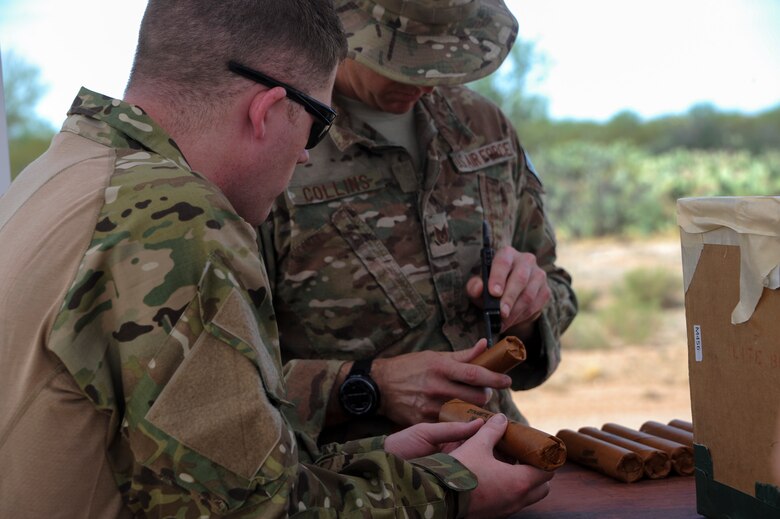 U.S. Air Force Staff Sgt. Michael McNally, 355th Maintenance Group scheduler, observes as Tech. Sgt. David Collins, 355th Civil Engineer Squadron explosive ordnance disposal flight NCO in charge of training, prepares a stick of dynamite for detonation during an EOD immersion course at Davis-Monthan Air Force Base, Ariz., June 28, 2016. EOD technicians must be able to perform intricate procedures under high-stress conditions in all kinds of environments. (U.S. Air Force photo by Airman Nathan H. Barbour/Released)