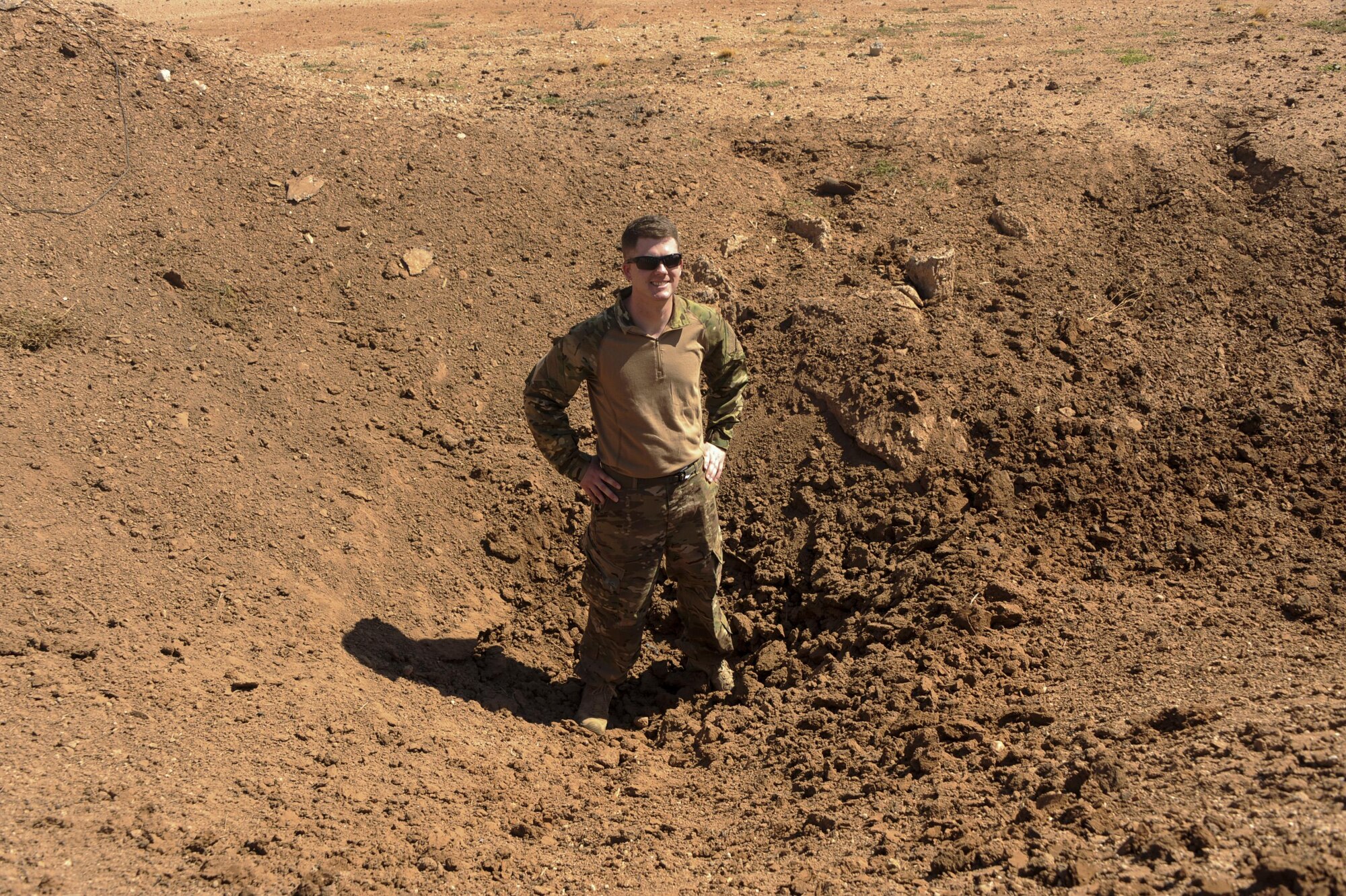 Staff Sgt. Michael McNally, 355th Maintenance Group scheduler, stands in a pit during an explosive ordnance disposal immersion course at Davis-Monthan Air Force Base, Ariz., June 28, 2016. The career field may attract Airmen because of how the risks involved encourage strong bonds between wingmen. (U.S. Air Force photo by Airman Nathan H. Barbour/Released)