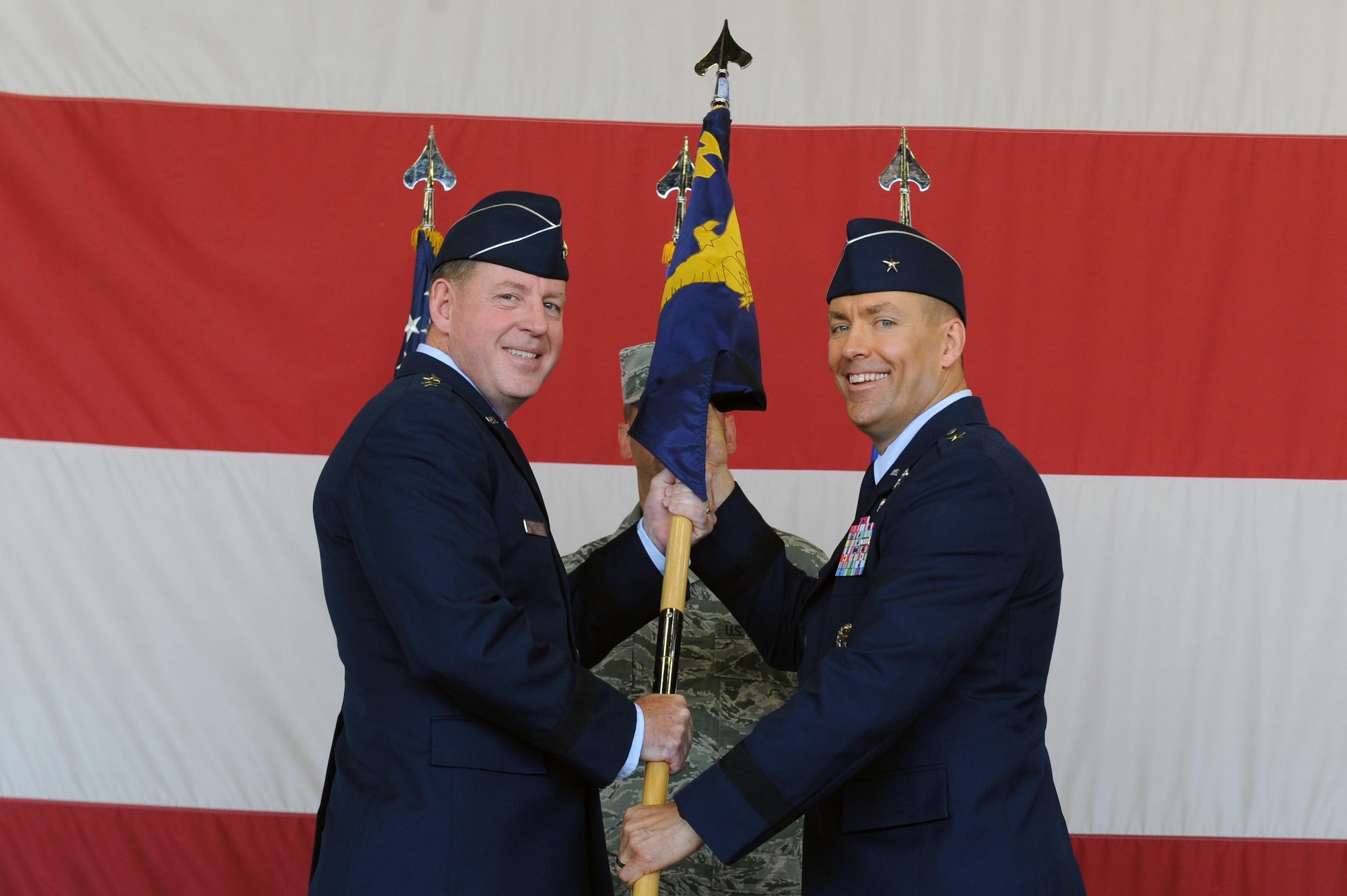 Maj. Gen. James Hecker, 19th Air Force commander, hands the guidon to the incoming commander Brig. Gen. Brook Leonard at Luke Air Force Base, Arizona, July 13, 2016. Leonard will be the commander of the 56th Fighter Wing. (U.S. Air Force photo by Airman 1st Class Pedro Mota)