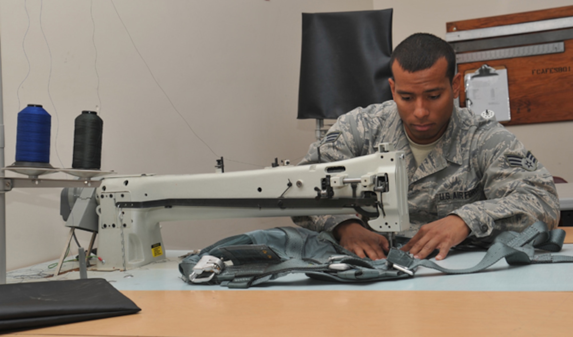 Senior Airman Kyle Boddie, 92nd Operations Support Squadron aircrew flight equipment journeyman, sews a pocket to a restraining harness July 7, 2016, at Fairchild Air Force Base, Wash. The restraining harness is used to attach an aircrew member to the jet in case of an emergency. As an aircrew flight equipment journeyman, Boddie fixes restraining harnesses, packs and inspects escape slides, 20-man life rafts, infant cots, adult and child life jackets, HGU 55/P pilot helmets and MBU 20/P 12/P oxygen breathing masks. (U.S. Air Force photo/Staff Sgt. Samantha Krolikowski)