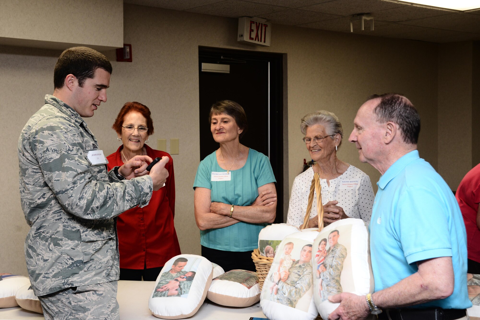 Capt. John Dolan, 375th Civil Engineer Squadron Environmental Assurance shows members of the Sweet Dreams Pillow Project photos of his children on his phone during a pre-deployment event June 14 at Scott Air Force Base.  During the event, deployers and their families received a variety of briefings on the services that are available to them during their time apart. (U.S. Air Force photo by Samantha Schaffer) 